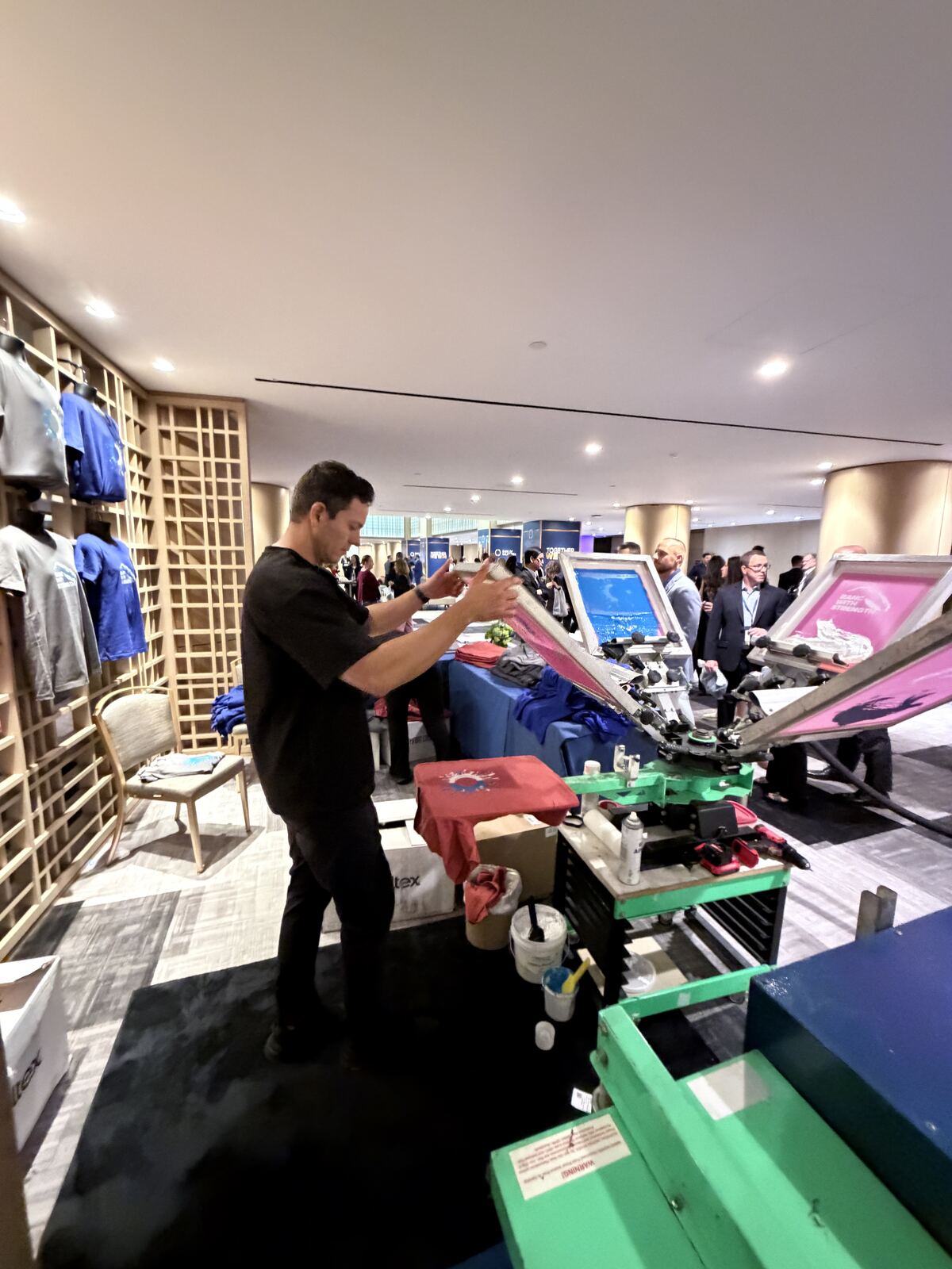 Overhead view of booth attendants with decorative apparel displays at an event space